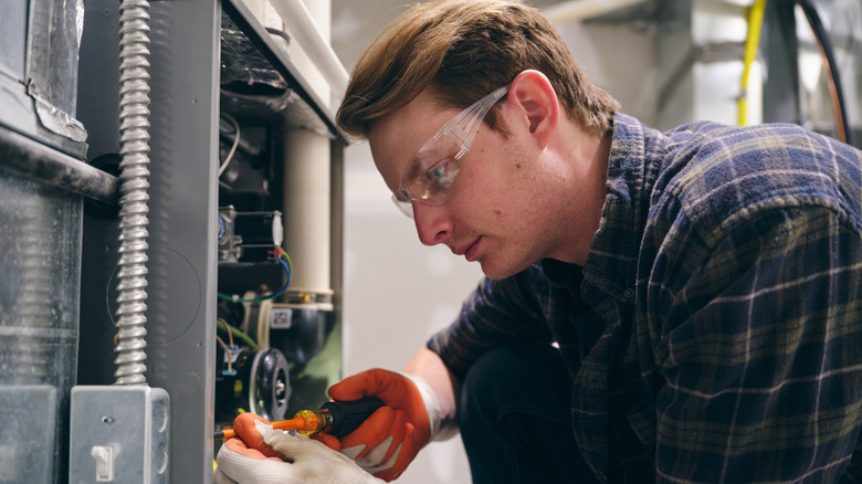 repairman working on old gas furnace