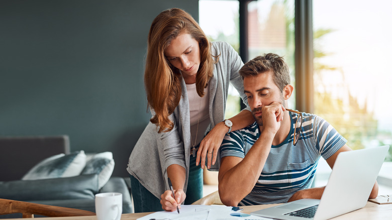 A couple look over their finances with concern.