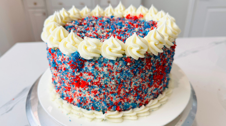 Fourth of July cake with red, white, and blue sprinkles and rosette frosting design