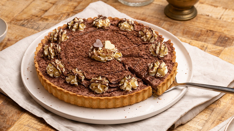Nutella cream pie decorated with swirls of whipped cream and chocolate hearts