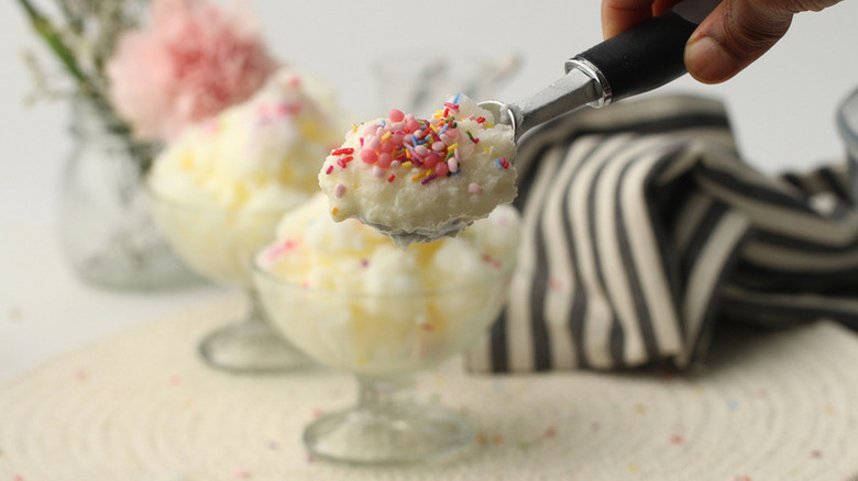 Hand scooping snow cream dessert from dessert glass