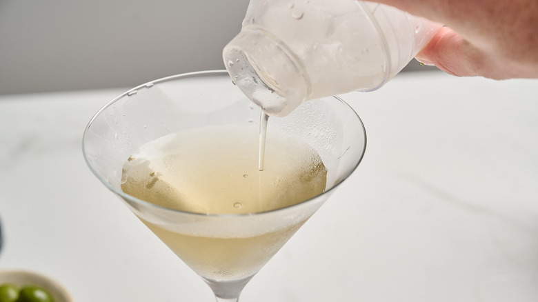 straining martini into martini glass