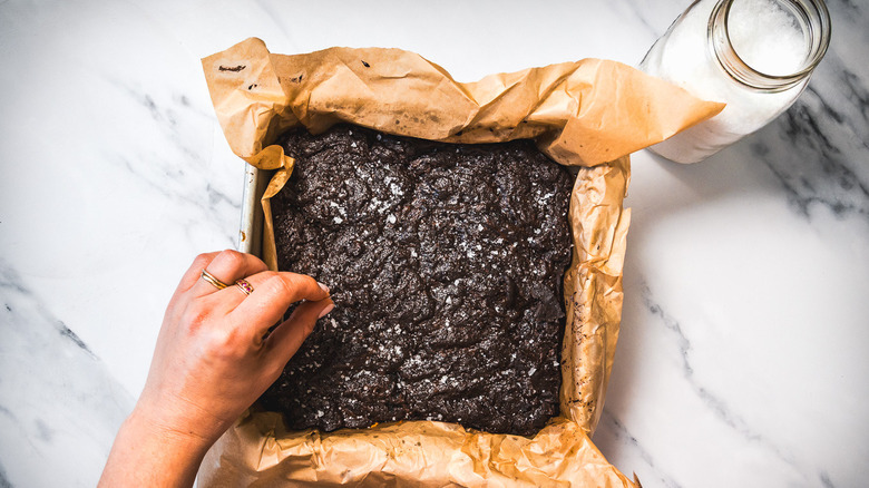 Topping brownies with salt.