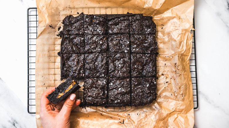 Hand holding one brownie over others.