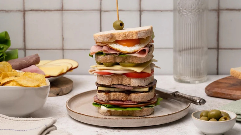 Loaded Dagwood Sandwich stacked on beige plate