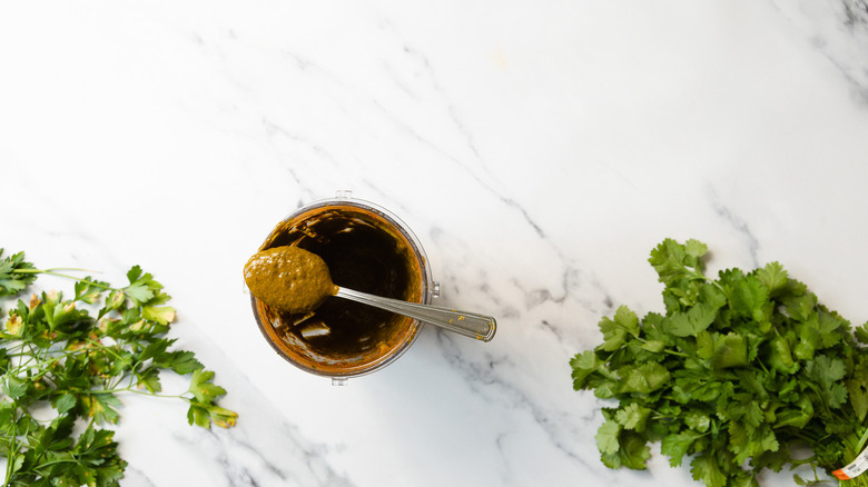 Chermoula on spoon over blender cup