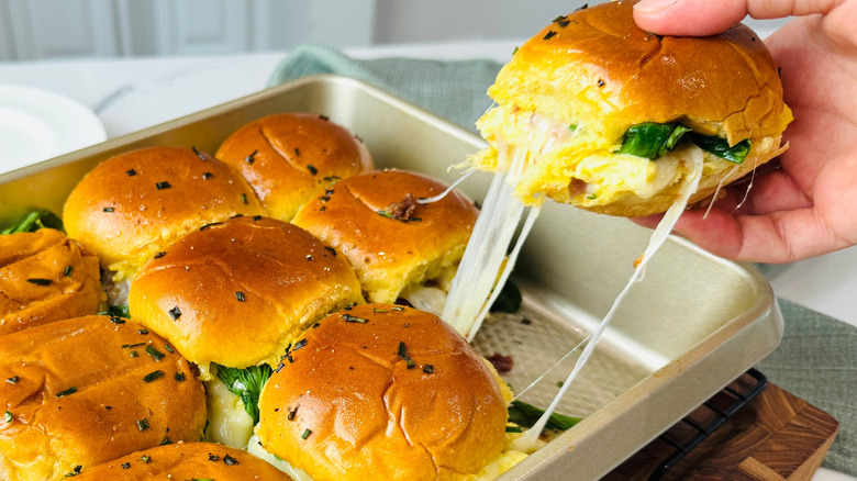 Hand removing slider from pan with more sliders