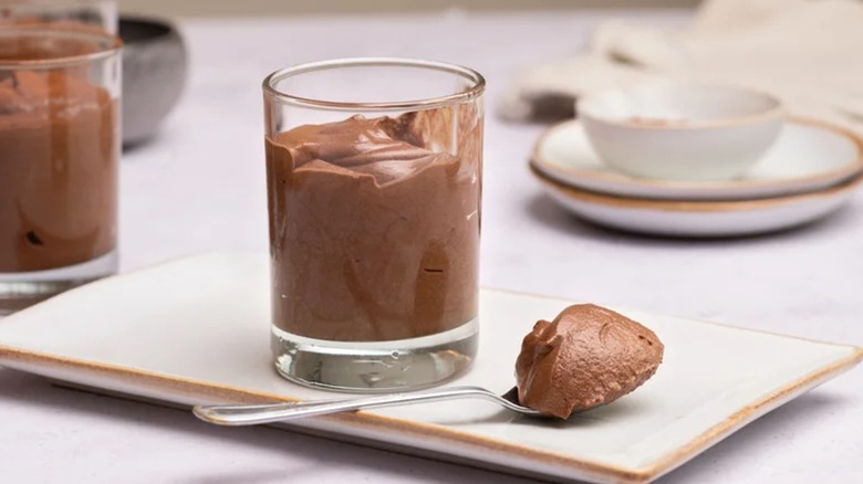 Glass cup of chocolate mousse on white dish