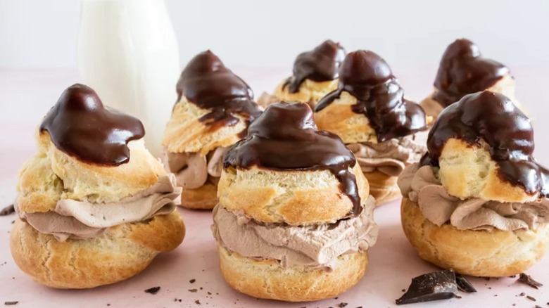 Chocolate cream puffs on white surface