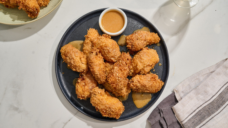 fried wings coated in coconut sauce on a plate
