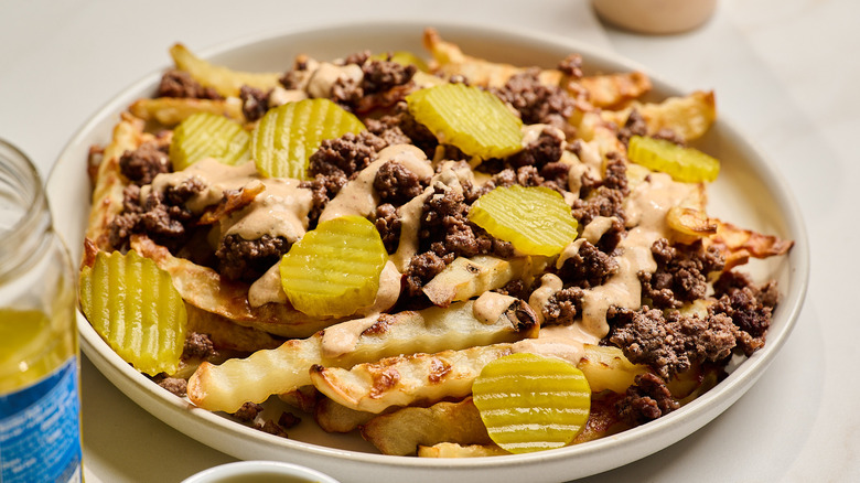 platter of fries covered with beef and pickles