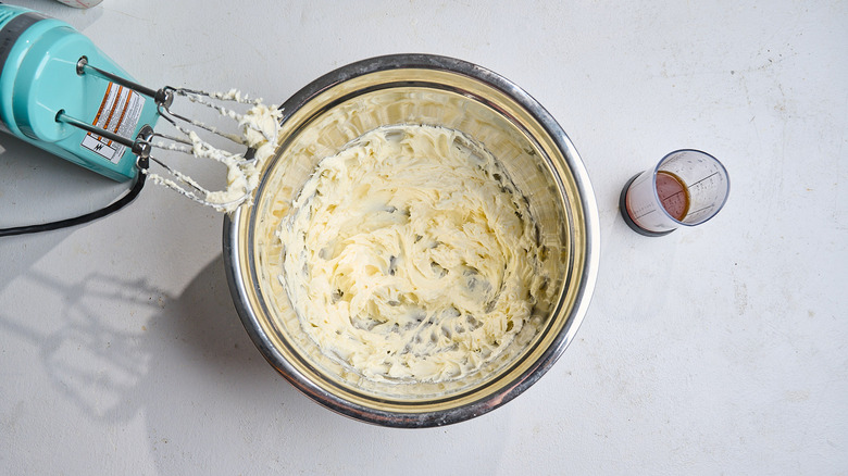 beating butter and cream cheese together in a bowl