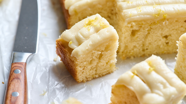 slices of cake on a table next to sheet cake