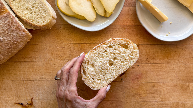 hand topping sandwich with bread