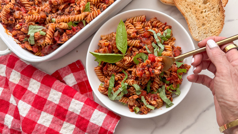 hand with fork in pasta