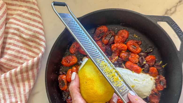 hands zesting lemon over pan