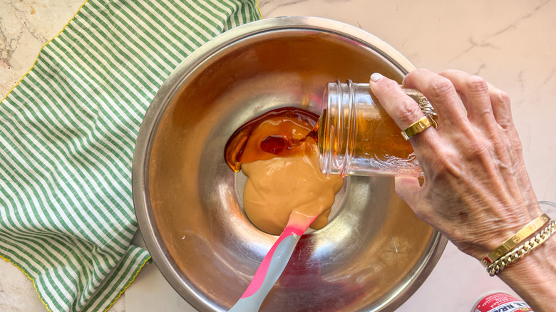 hand pouring cider into bowl