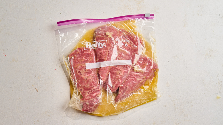 steaks covered in marinade in a bag