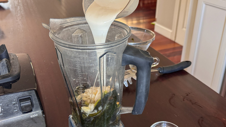 adding milk to blender