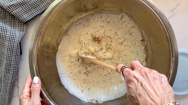 hand stirring creamy soup mixture in bowl