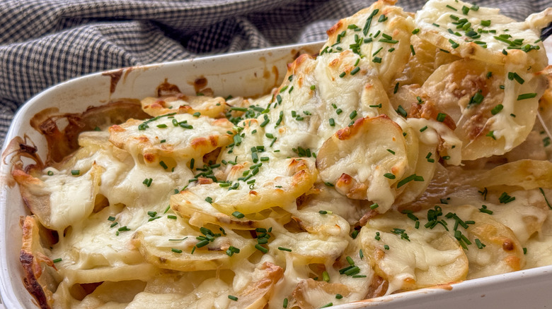 Spoonful of cheesy onion bake being removed from dish