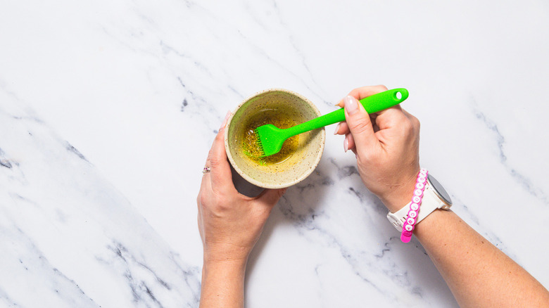 Hand dipping silicone brush into oil