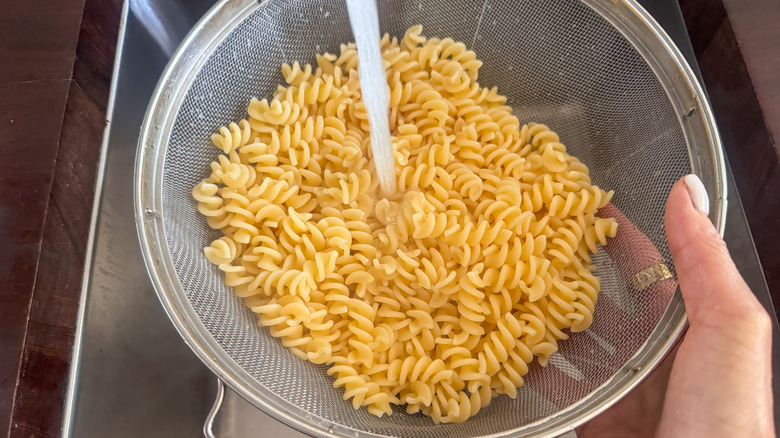 hand rinsing pasta under water