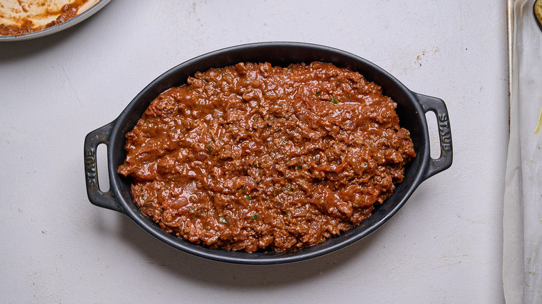 meat sauce layered into casserole dish