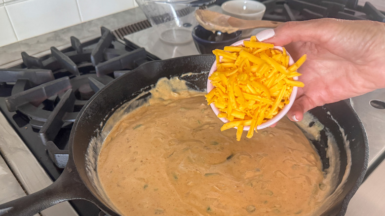 hand adding cheese