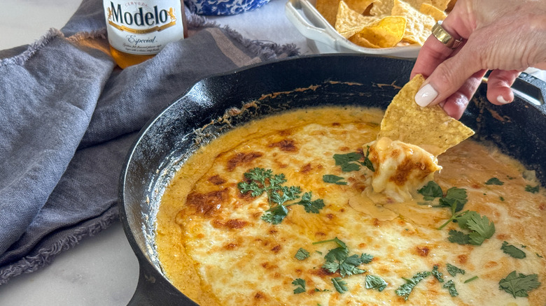 hand dipping chip into dip