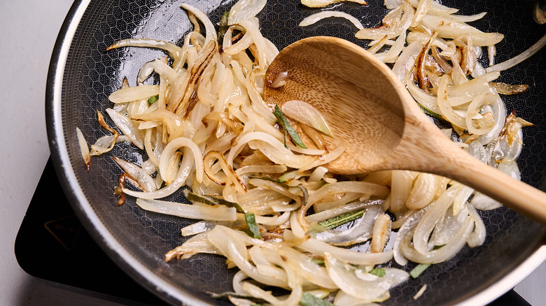 cooking sage with onions in a skillet