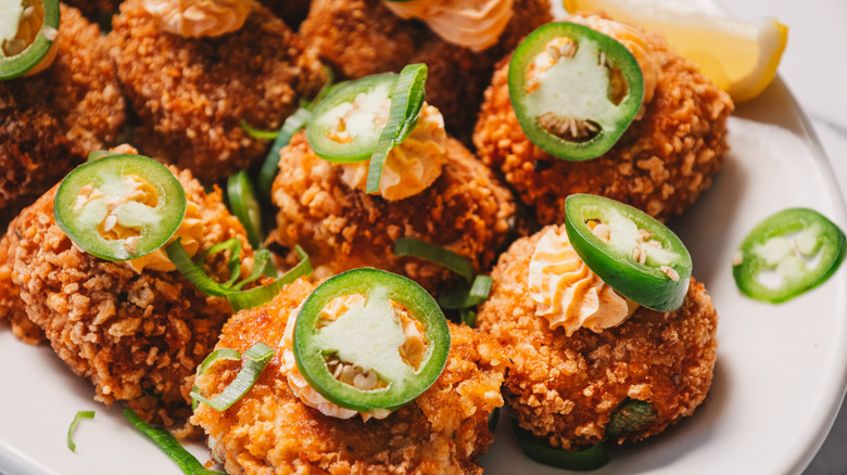 Close up on crab cake jalapeño popper bites on a white platter