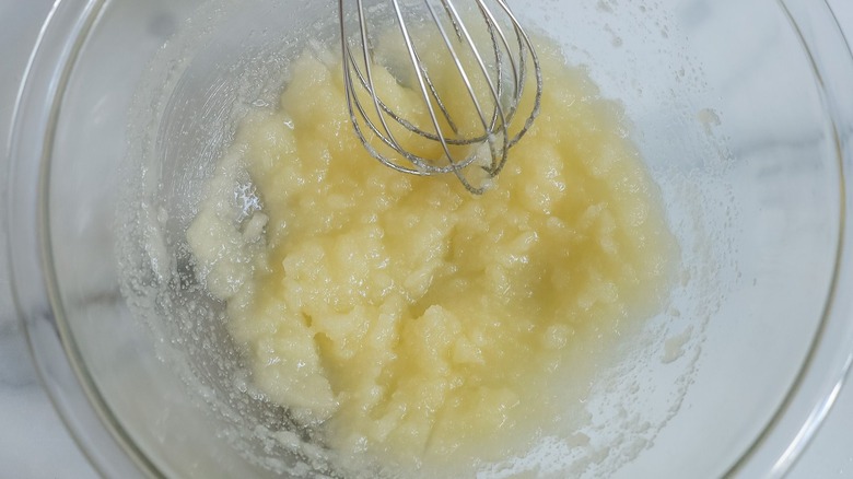 Melted butter and sugar mixture with whisk in bowl