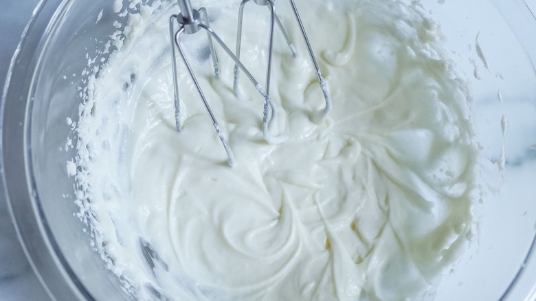 Beaten cream cheese in bowl with mixers