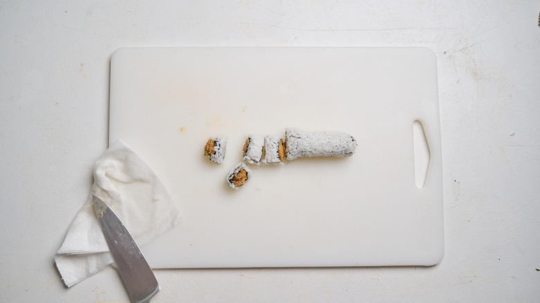 slicing sushi into small pieces