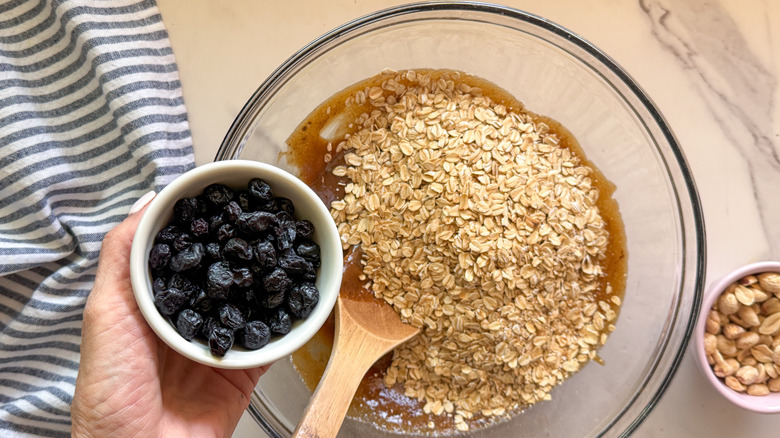 hand adding blueberries to bowl