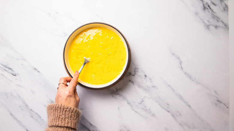 Hand whisking eggs in bowl